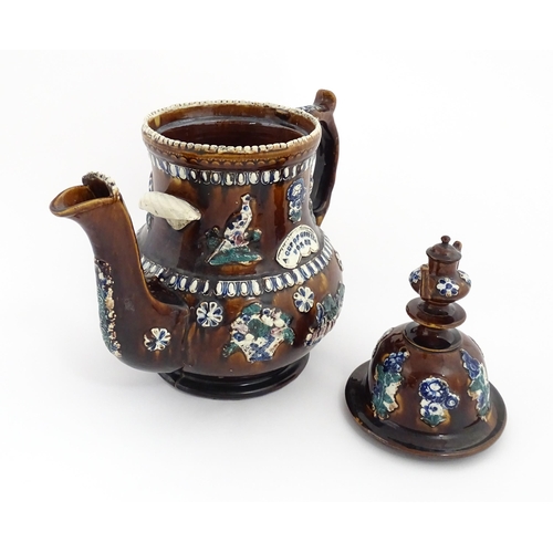 75 - A large Victorian Measham bargeware teapot with miniature teapot finial, decorated with applied flor... 