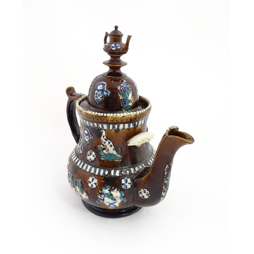 75 - A large Victorian Measham bargeware teapot with miniature teapot finial, decorated with applied flor... 