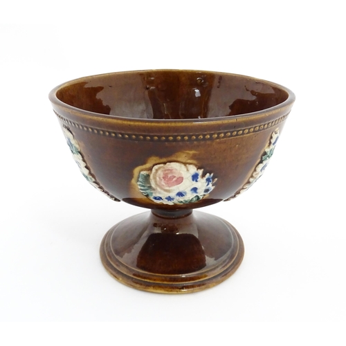 76 - A Victorian Measham bargeware pedestal bowl with applied floral decoration and beaded border. Approx... 