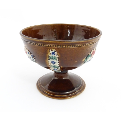 76 - A Victorian Measham bargeware pedestal bowl with applied floral decoration and beaded border. Approx... 