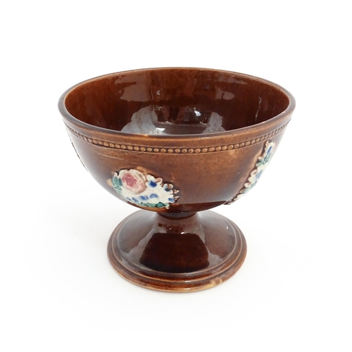 76 - A Victorian Measham bargeware pedestal bowl with applied floral decoration and beaded border. Approx... 