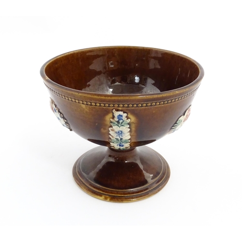 76 - A Victorian Measham bargeware pedestal bowl with applied floral decoration and beaded border. Approx... 