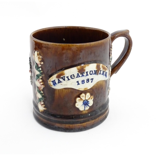 77 - A Victorian Measham mug with applied floral and foliate decoration and plaque inscribed Navigation I... 