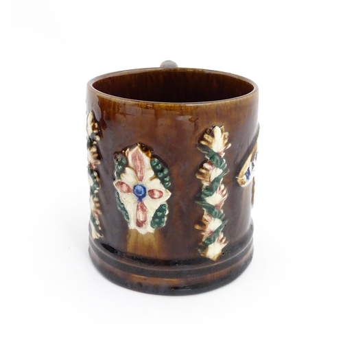 77 - A Victorian Measham mug with applied floral and foliate decoration and plaque inscribed Navigation I... 