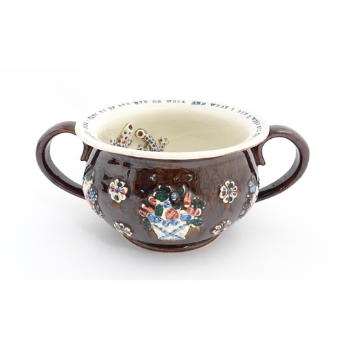 78 - A Victorian Measham bargeware twin handled chamber pot, the exterior with applied flower decoration,... 