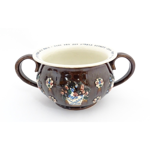 78 - A Victorian Measham bargeware twin handled chamber pot, the exterior with applied flower decoration,... 