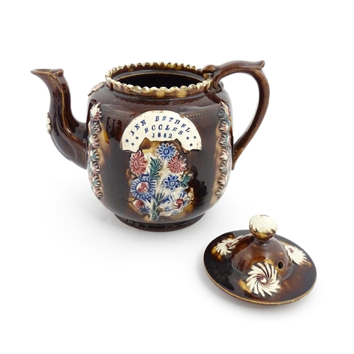 81 - A Victorian Measham bargeware teapot decorated with applied flower detail and plaque inscribed Ann B... 