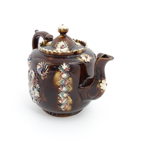 81 - A Victorian Measham bargeware teapot decorated with applied flower detail and plaque inscribed Ann B... 