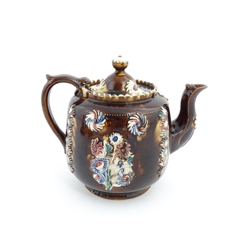 81 - A Victorian Measham bargeware teapot decorated with applied flower detail and plaque inscribed Ann B... 