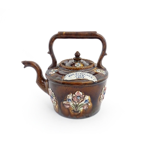 84 - A Victorian Measham bargeware teapot decorated with applied flower detail and plaque inscribed God B... 