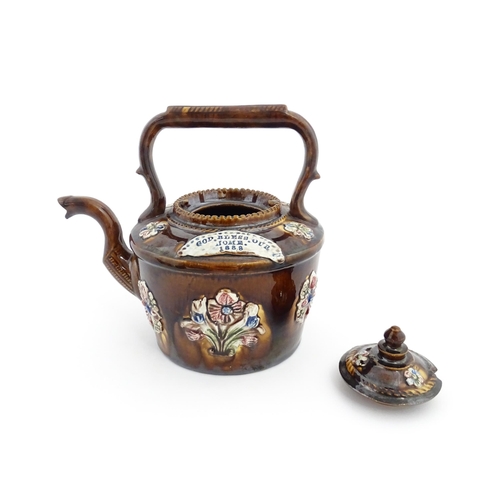 84 - A Victorian Measham bargeware teapot decorated with applied flower detail and plaque inscribed God B... 