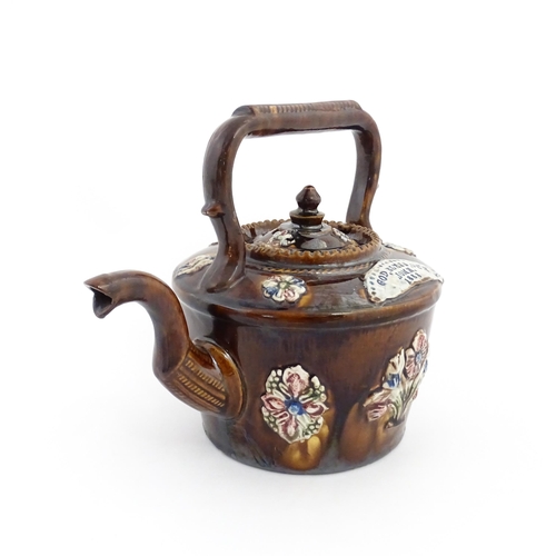 84 - A Victorian Measham bargeware teapot decorated with applied flower detail and plaque inscribed God B... 