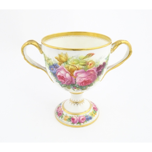 90 - A Cauldon loving cup with gilt highlights and hand painted decoration depicting flowers and foliage ... 