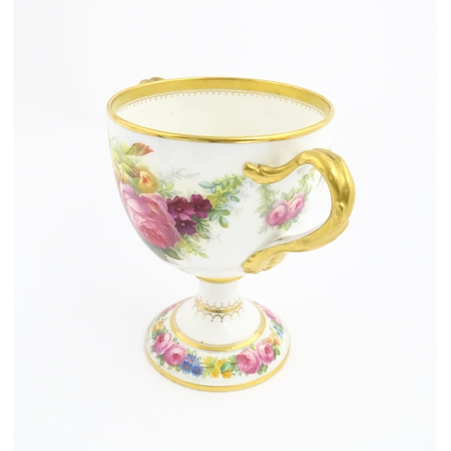 90 - A Cauldon loving cup with gilt highlights and hand painted decoration depicting flowers and foliage ... 