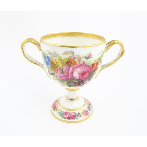 90 - A Cauldon loving cup with gilt highlights and hand painted decoration depicting flowers and foliage ... 