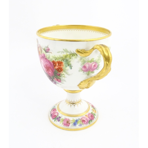 90 - A Cauldon loving cup with gilt highlights and hand painted decoration depicting flowers and foliage ... 