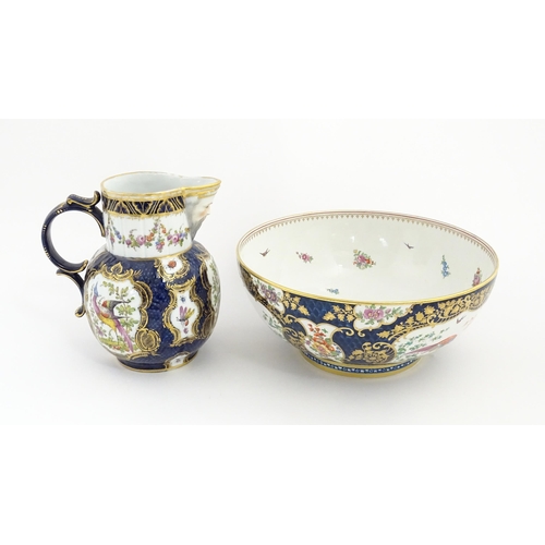 94 - A Worcester style jug and wash bowl with cobalt blue ground decorated with hand painted exotic birds... 