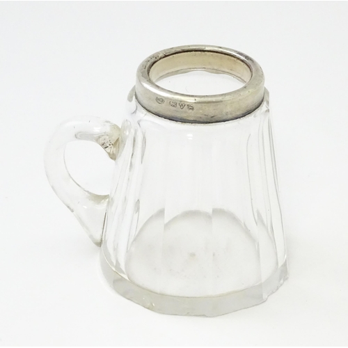 280 - A small glass mug with silver rim hallmarked Chester 1910, maker Richard Owen Williams. Approx 2 1/4... 