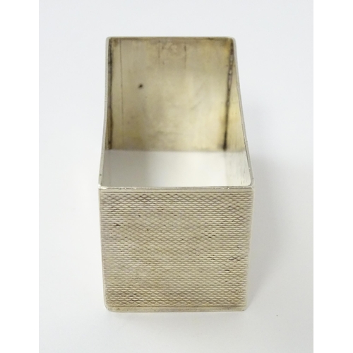 332 - An Art Deco silver napkin ring of rectangular form with engine turned decoration. Hallmarked Birming... 