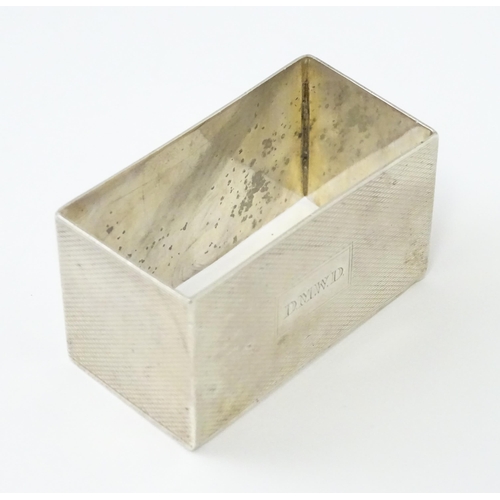 332 - An Art Deco silver napkin ring of rectangular form with engine turned decoration. Hallmarked Birming... 