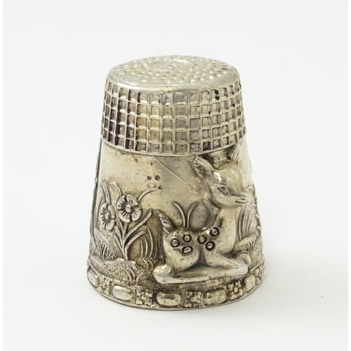 345 - A silver thimble with fawn / deer /  Bambi detail. Marked Sterling.