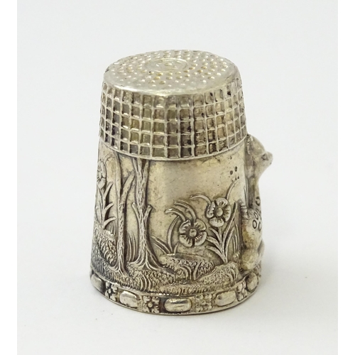 345 - A silver thimble with fawn / deer /  Bambi detail. Marked Sterling.