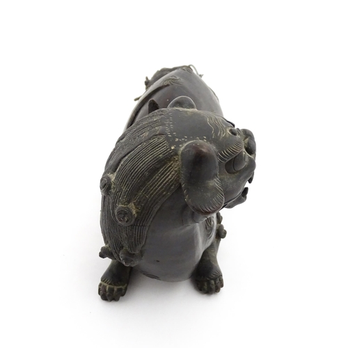 1003 - A Chinese bronze censer modelled as a temple lion / foo dog with engraved decoration. Approx. 12