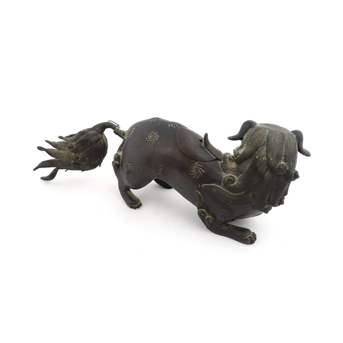 1003 - A Chinese bronze censer modelled as a temple lion / foo dog with engraved decoration. Approx. 12