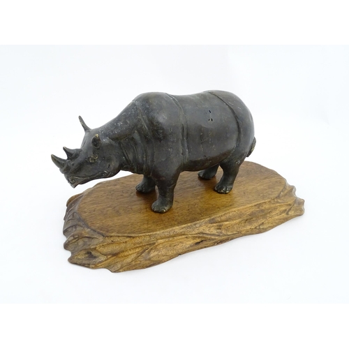 1006 - A Chinese bronze model of a rhinoceros standing. Together with a carved wooden stand. Rhino approx. ... 