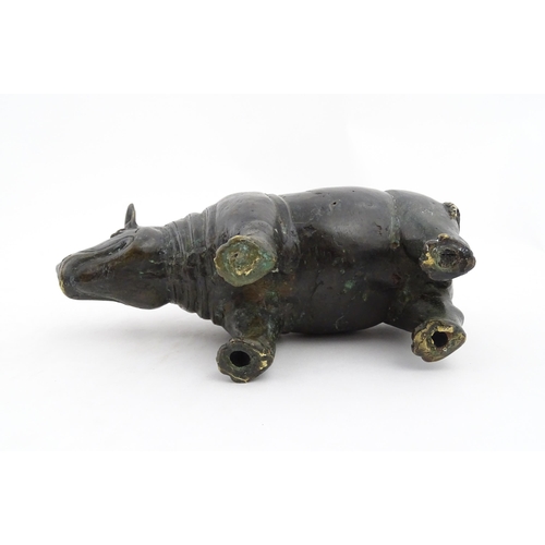 1006 - A Chinese bronze model of a rhinoceros standing. Together with a carved wooden stand. Rhino approx. ... 