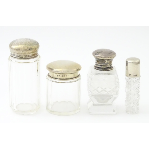 436 - Four assorted glass dressing table jars with silver tops, to include scent bottles etc. Largest appr... 