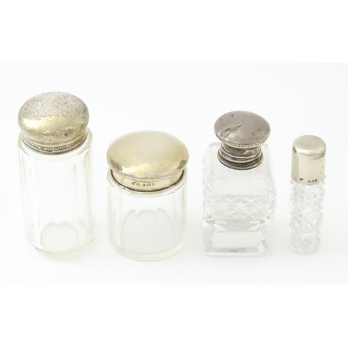 436 - Four assorted glass dressing table jars with silver tops, to include scent bottles etc. Largest appr... 