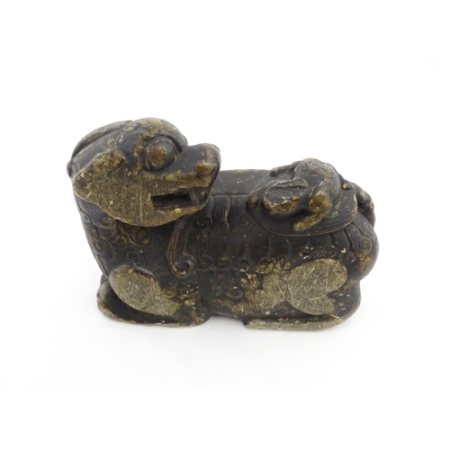 1009 - A Chinese soapstone carving modelled as a stylised temple lion and cub. Approx. 5 3/4