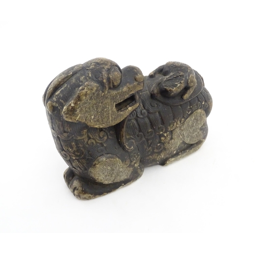 1009 - A Chinese soapstone carving modelled as a stylised temple lion and cub. Approx. 5 3/4