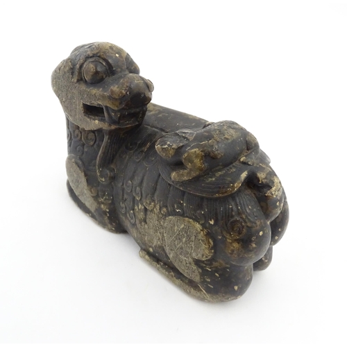 1009 - A Chinese soapstone carving modelled as a stylised temple lion and cub. Approx. 5 3/4