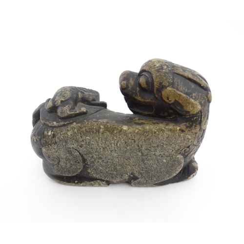 1009 - A Chinese soapstone carving modelled as a stylised temple lion and cub. Approx. 5 3/4