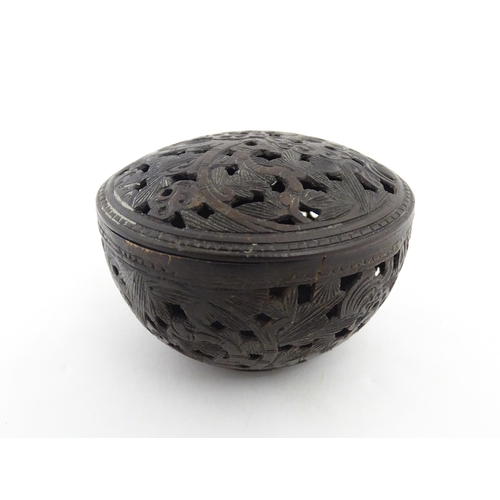 1010 - A small Chinese carved coconut pot and cover with foliate and pierced decoration. Approx. 2 1/2