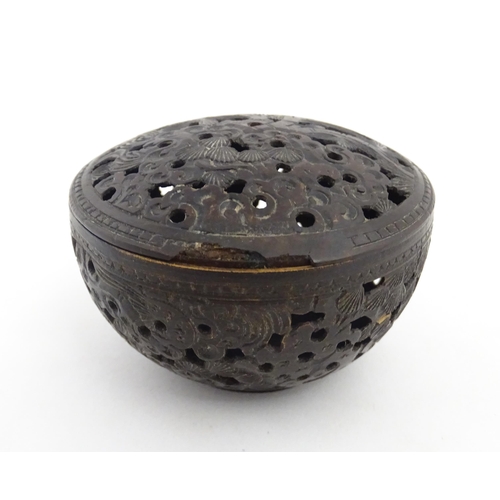 1010 - A small Chinese carved coconut pot and cover with foliate and pierced decoration. Approx. 2 1/2