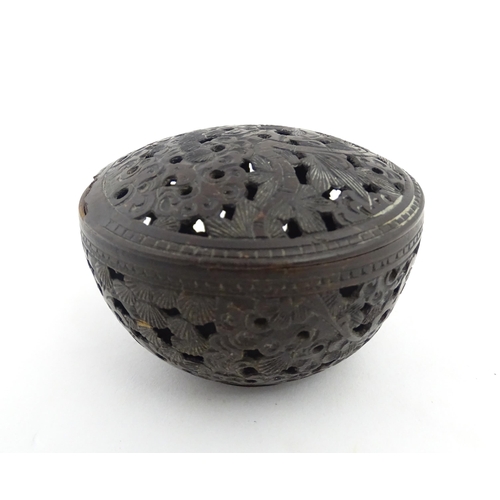 1010 - A small Chinese carved coconut pot and cover with foliate and pierced decoration. Approx. 2 1/2