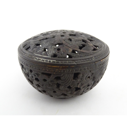 1010 - A small Chinese carved coconut pot and cover with foliate and pierced decoration. Approx. 2 1/2