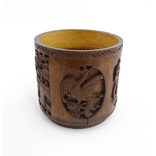 1019 - An Oriental carved bamboo brush pot with panelled decoration depicting figures and birds. Character ... 