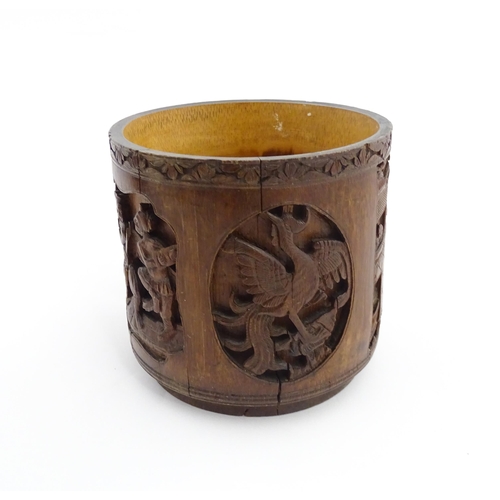 1019 - An Oriental carved bamboo brush pot with panelled decoration depicting figures and birds. Character ... 