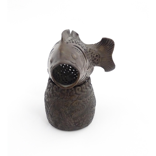 1020 - A Chinese bronze incense burner modelled as a fish on a stand decorated with crashing waves. Charact... 