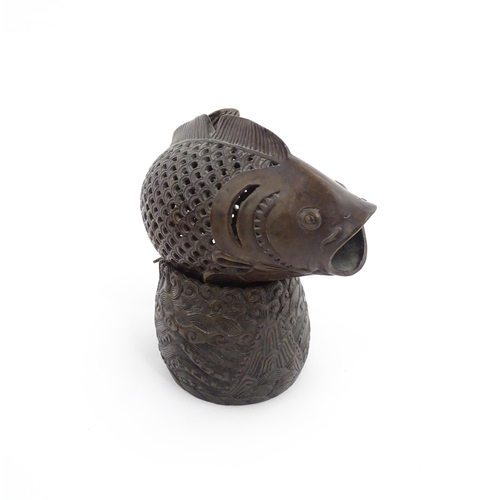 1020 - A Chinese bronze incense burner modelled as a fish on a stand decorated with crashing waves. Charact... 