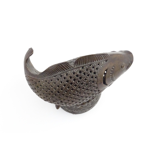 1020 - A Chinese bronze incense burner modelled as a fish on a stand decorated with crashing waves. Charact... 