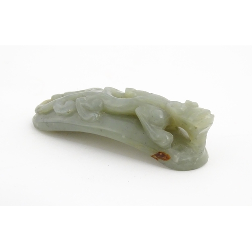 1022 - A Chinese carved jade coloured hardstone belt hook depicting a stylised chilong dragon. Approx. 3 1/... 