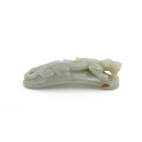 1022 - A Chinese carved jade coloured hardstone belt hook depicting a stylised chilong dragon. Approx. 3 1/... 