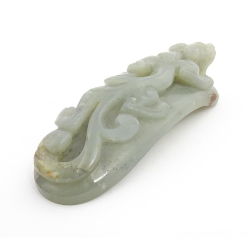 1022 - A Chinese carved jade coloured hardstone belt hook depicting a stylised chilong dragon. Approx. 3 1/... 