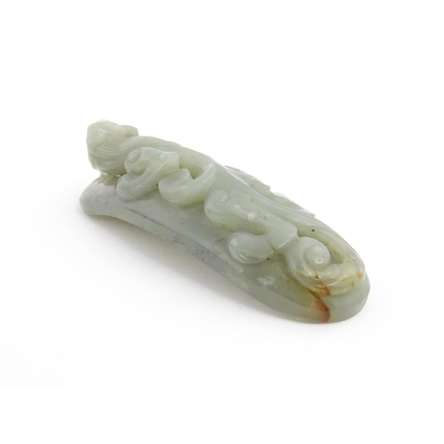 1022 - A Chinese carved jade coloured hardstone belt hook depicting a stylised chilong dragon. Approx. 3 1/... 