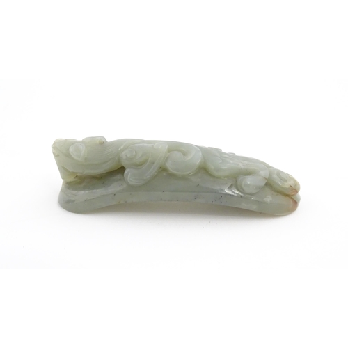 1022 - A Chinese carved jade coloured hardstone belt hook depicting a stylised chilong dragon. Approx. 3 1/... 